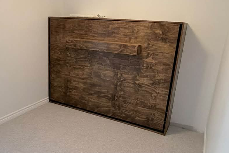 Built-in wood murphy bed cabinetry with matched wood grain