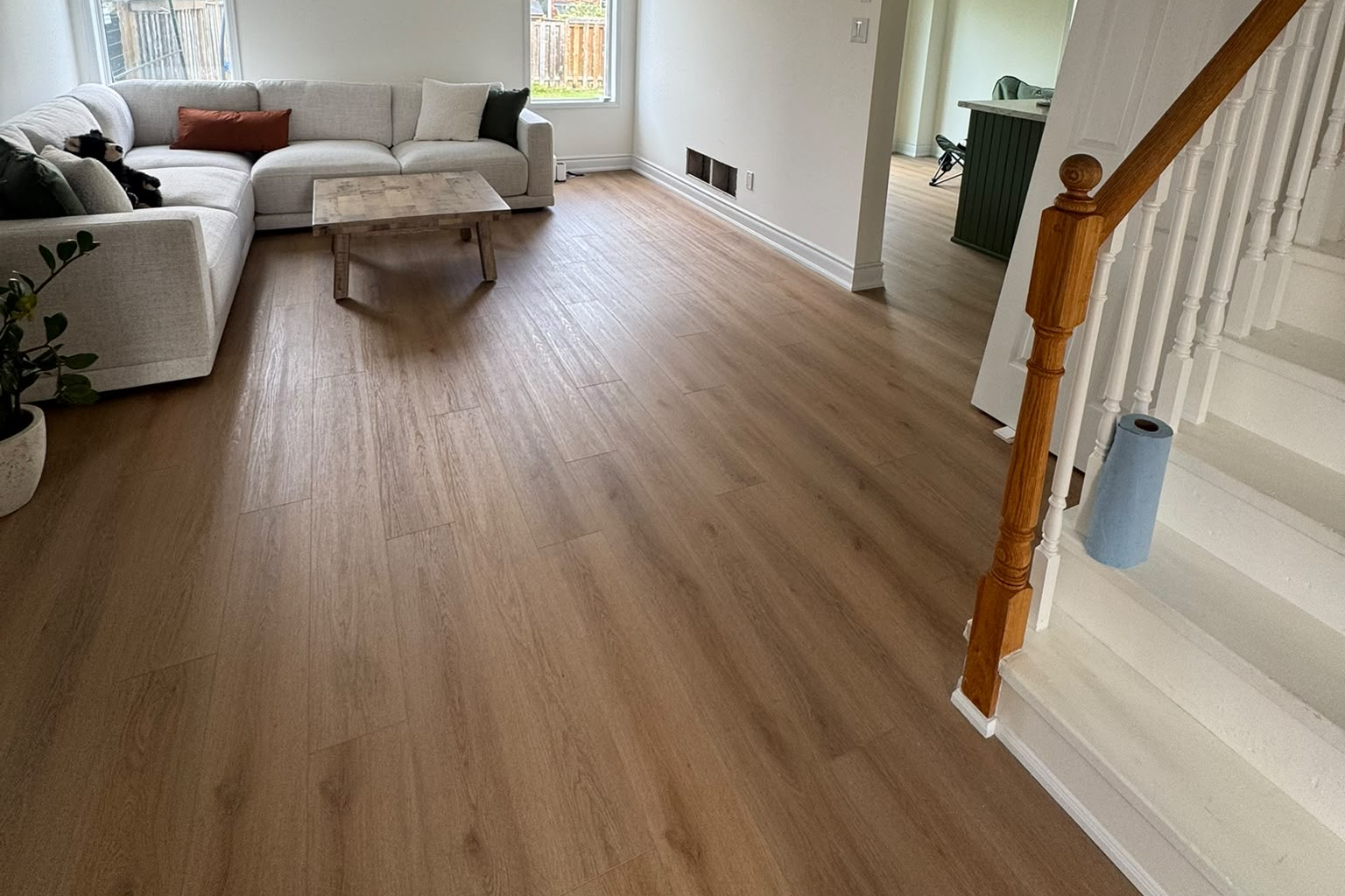 Open-concept living room with wide-plank flooring and staircase