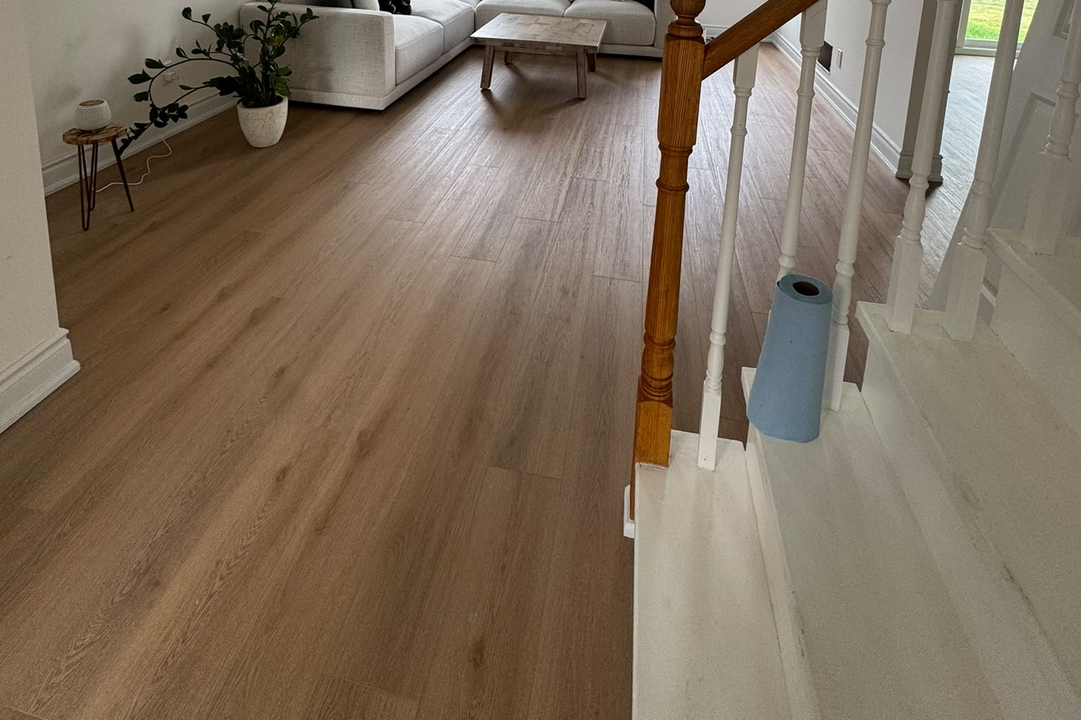 Living room and staircase with laminate flooring flowing throughout