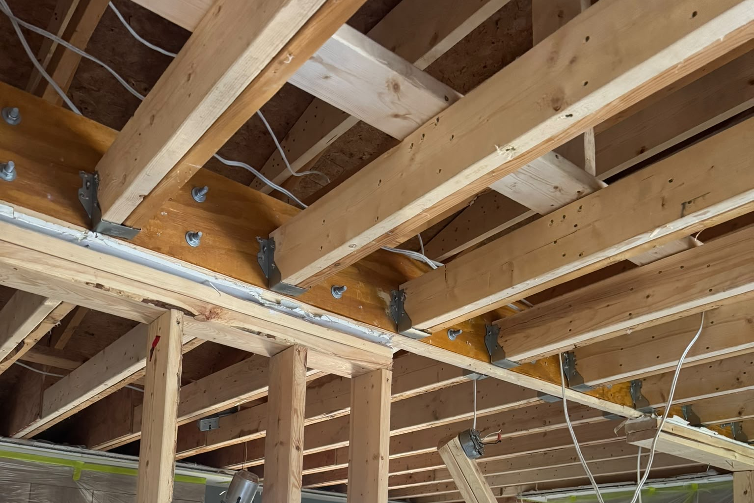 Ceiling joists with hangers and wiring exposed
