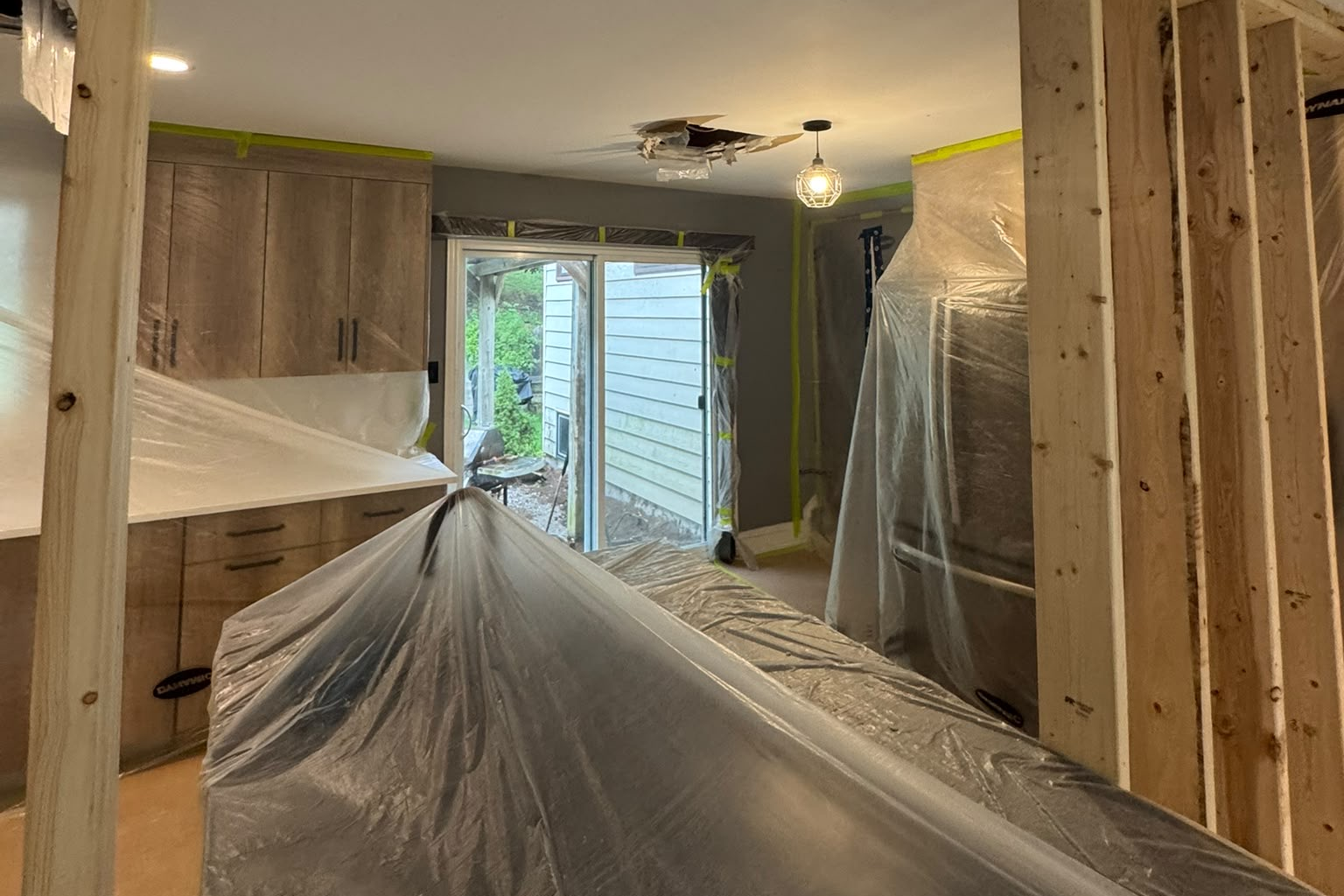 Kitchen mid-renovation with wood cabinets installed and framing exposed