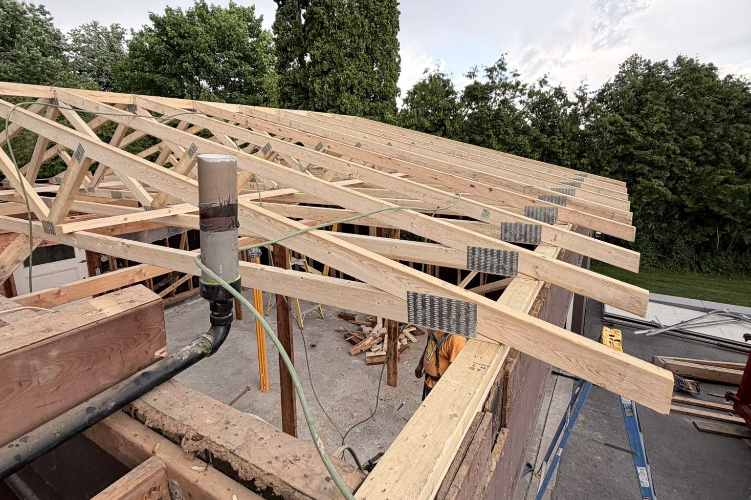 Roof truss framing under construction with worker